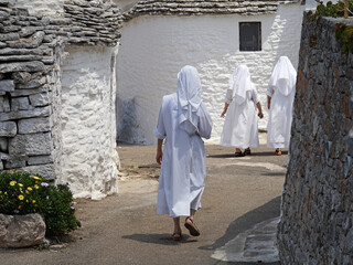 Naklejka premium Historic street with Trullo (Trulli) stone houses with conical roof, popular tourist travel destination