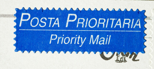 Aufkleber Posta Prioritaria, Priority Mail und Poststempel auf einer Postkarte