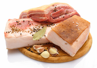 raw pork meat and lard with salt, spices and garlic on a cutting board, white background