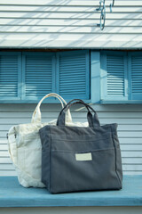 Stylish eco bags outdoor on wooden counter