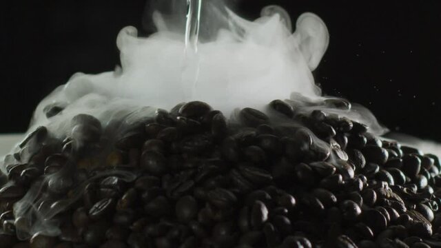 Erupting volcano made of coffee beans, slow motion shot