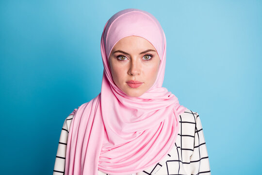 Photo of attractive young muslim woman wear hijab confident serious isolated over blue color background