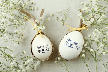 Easter bunnies made of eggs and gypsophila flowers on white textured background