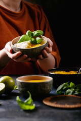 Female holding ceramic bowl of yellow curry