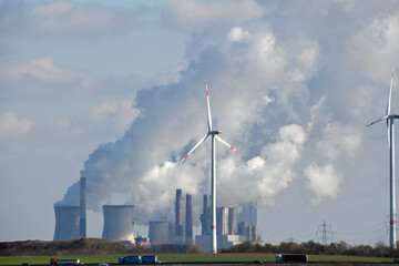 Braunkohlekraftwerk mit Kühltürmen und Windkrafträdern im Vordergrund