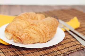 crispy croissants on a plate kitchen utensils for breakfast meal dessert