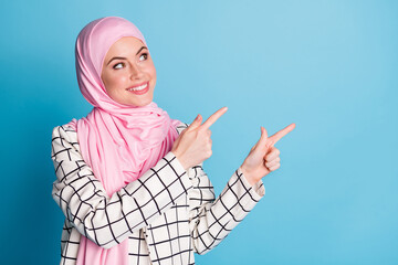 Close-up portrait of pretty cheerful muslimah girl showing copy space advert advice isolated over...