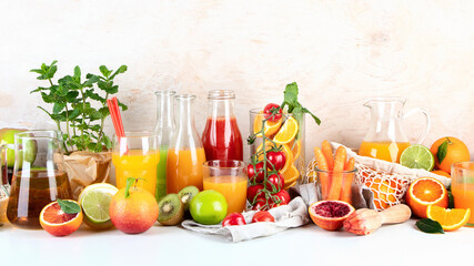 Healthy home made juices and fruits on light wooden background