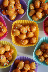 Traditional italian fried Struffoli with honey and sugar sprinkles  on a plate 
