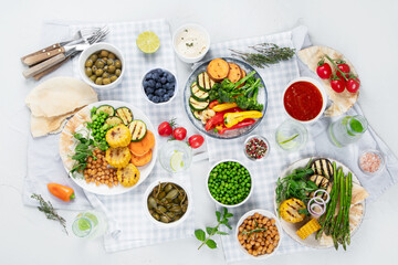 Delicious grilled vegetables with sauces and snacks served on light gray background.