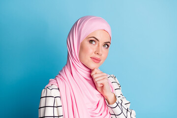 Close-up portrait of lovely pensive muslimah girl touching chin creating strategy isolated over...