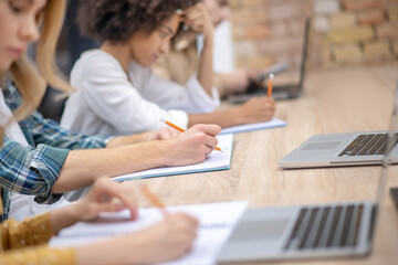 Close up picture of students making notes during the lecture