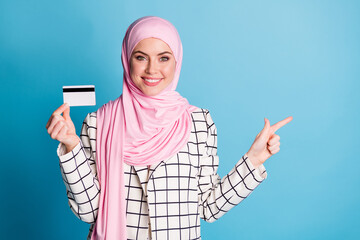 Portrait of pretty rich cheerful muslimah girl holding in hand bank card showing copy space...