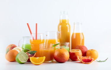 Raw fresh citrus juices and fruints in glasses and bottles