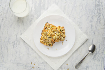 Homemade cookies with cereals and nuts with milk on a marble table.