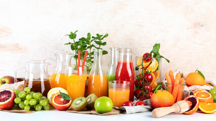 Healthy home made juices and fruits on light wooden background