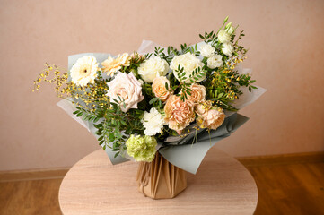 Beautiful flowers in vase on a table with beige background. Women's, mother's day, love concept. Spring, summer season.