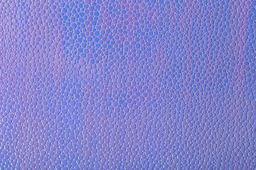 Abstract background with artificial leather shot close-up. Stock macro texture. Imitation of purple scales.