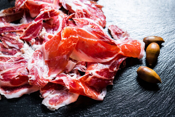 Iberian Ham. acorn-fed Iberian ham. Portion of Iberian ham on slate