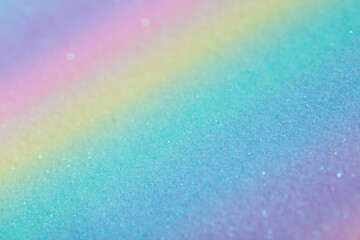 Iridescent rainbow background with glitter. Gradient texture with fine sparkles, macro photography