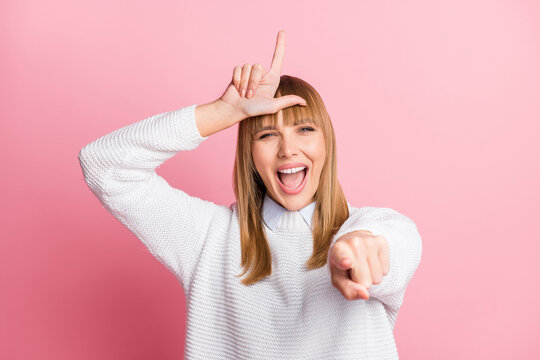 Photo of young smiling cheerful abusive arrogant woman laughing point finger at you isolated on pink color background