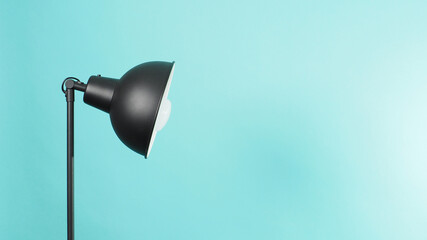 Lamp Floor uplighter.In black color and Light bulb made with  Metal, rugged constructions on green...