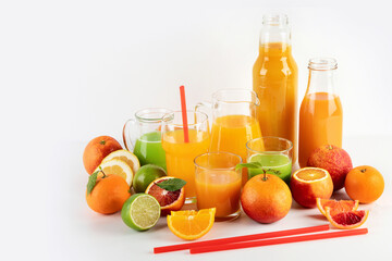 Variety of citrus juices and fruits on white background