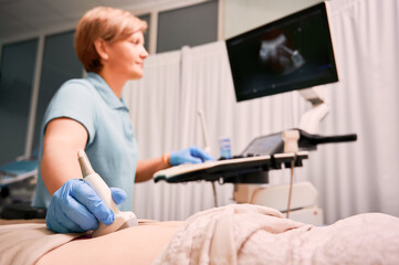 Doctor performing ultrasound procedure in modern clinic.