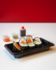 Side view of fresh take away sushi on a white background with copy space