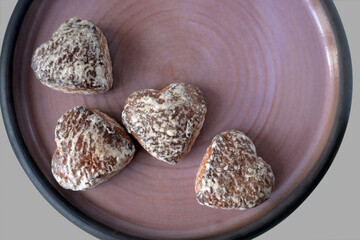 Gingerbread cookies in the form of a heart, laid out on a ceramic tray, isolated on a colored background. Top view. Holiday. Women's Day. Mother's Day. St. Valentine's Day. Valentine's Day. Love.