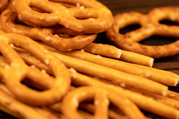 Salted breadsticks and salted pretzels scattered on the table.