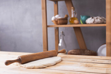 Fototapeta na wymiar Wheat dough at flour powder and rolling pin on table for homemade bread cooking or baking