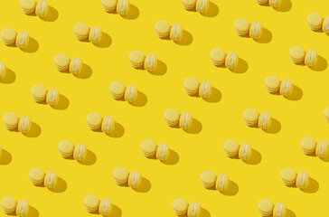 Yellow macarons pattern on yellow background. Sweet minimal concept.