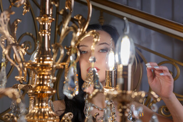 Portrait of a young beautiful woman at a glowing floor lamp