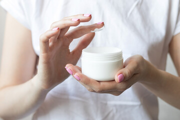Woman holding hand and body cream in her hands