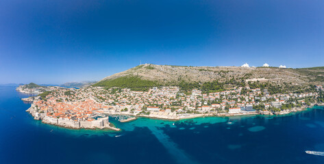 Aerial panorama drone shot of Dubrovnik old town coastline by Adriatic sea in Croatia summer noon