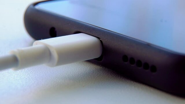 man hands plugging a charger in a smartphone. Cell Phone Connecting to charger