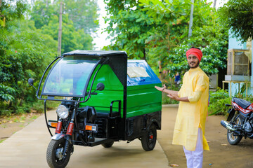 Young indian man standing with garbage van