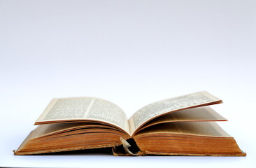 Open old book with text on white background