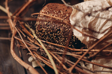 Loaf of Bread In a paper package lies on branches in a nest on a wooden table