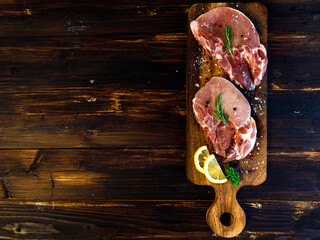 Pieces of fresh pork fillet prepare for steak with lemon put on a wooden plate