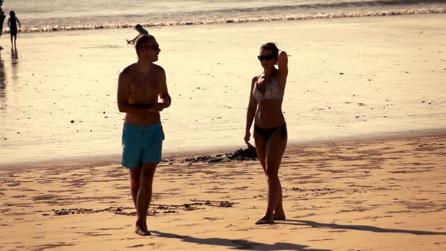 Bored, resentful couple walking on the beach, super slow motion
