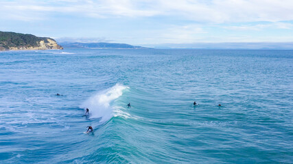 Aerial drone view of surfers riding perfect Atlantic waves in the south coast of Spain, Caños de...