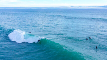 Aerial drone view of surfers riding perfect Atlantic waves in the south coast of Spain, Caños de...