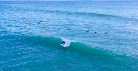 Naklejka premium Aerial drone view of surfers riding perfect Atlantic waves in the south coast of Spain, Caños de Meca near Trafalgar