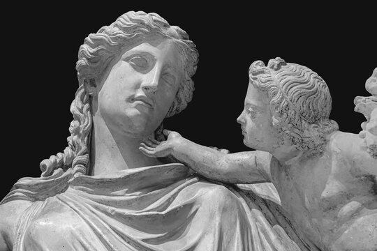 Antique statue of Eirene with the infant Ploutos isolated on black background. Goddess of Peace beautiful young woman carrying a cornucopia