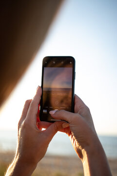 Taking Pictures Of Sunset By The Sea. Capture The Moment