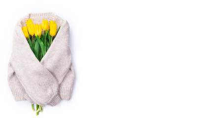 Bouquet of yellow tulips on white background knitted sweater with place for text, top view, bouquet of yellow tulips for women's day, concept of spring flowers