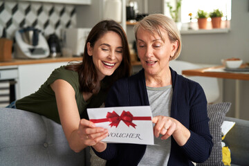 Happy mother reading card from daughter