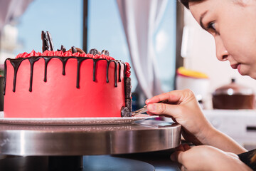 Hands decorating an appetizing cake.